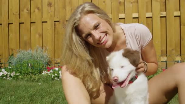 PORTRAIT: Jonge vrouw heeft plezier knuffelen met haar schattige puppy op zonnige dag. — Stockvideo