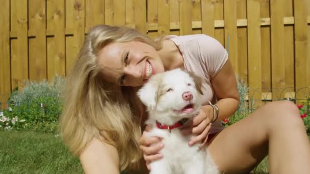PORTRAIT: Gelukkige blanke vrouw huisdieren pluizig hondje en kijkt naar de camera. — Stockvideo