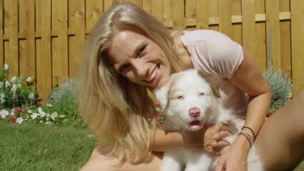 CERRAR: Adorable foto de una chica rubia acurrucada con un cachorro blanco suave. — Vídeos de Stock