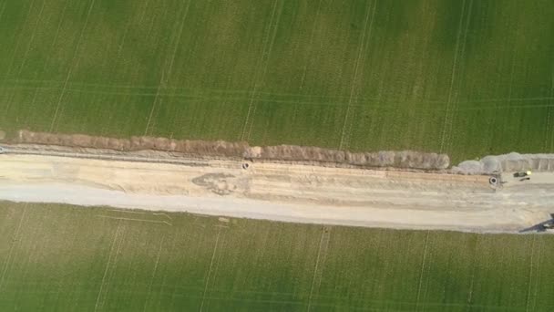 TOP DOWN: Flying above road under construction with heavy machinery and workers. — Stock Video