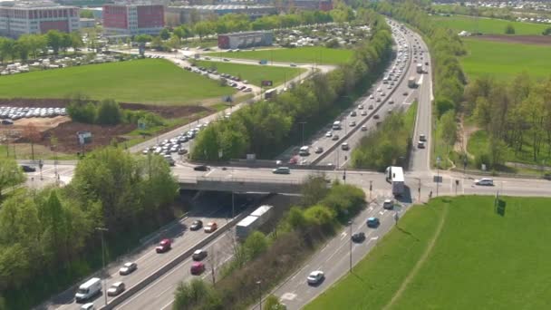 AERIAL: Volando alrededor de un paso elevado de la autopista que cruza la carretera concurrida en hora punta. — Vídeo de stock