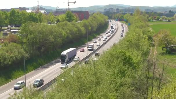 DRONE: Samochody i ciężarówki rejs wzdłuż ruchliwej autostrady w godzinach szczytu po południu. — Wideo stockowe