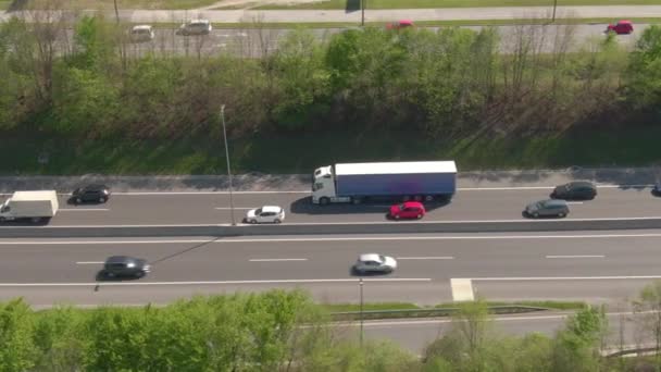 空気ラッシュ時に忙しい高速道路を運転する白いトラックに沿って飛ぶ — ストック動画