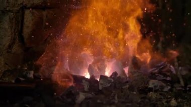 Tanınmayan kişi, tuğla fırının içindeki yangını çelik çubukla dürtüyor..