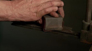 Erkek zanaatkar keskinleştiriyor ve geleneksel bıçak üzerinde çalışıyor..