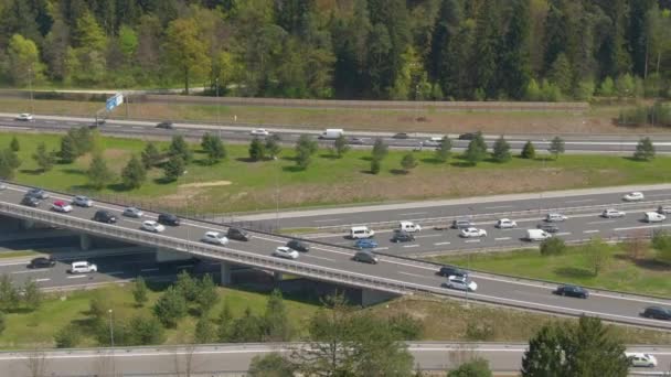 DRONE: Přetížený provoz se pohybuje podél mostu nad rušnou dálnicí. — Stock video