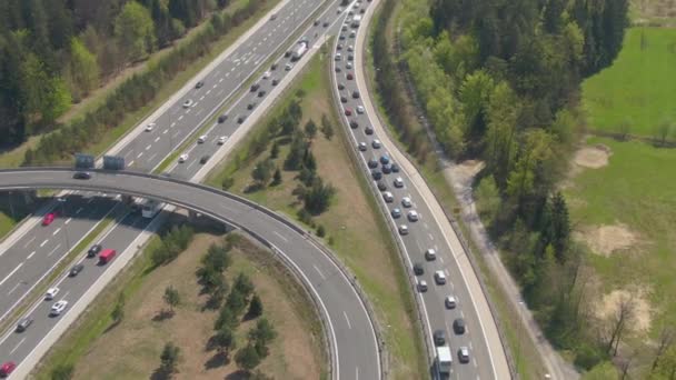 AERIAL: Övertygad trafik rör sig längs en överfart och mot en infartsväg. — Stockvideo