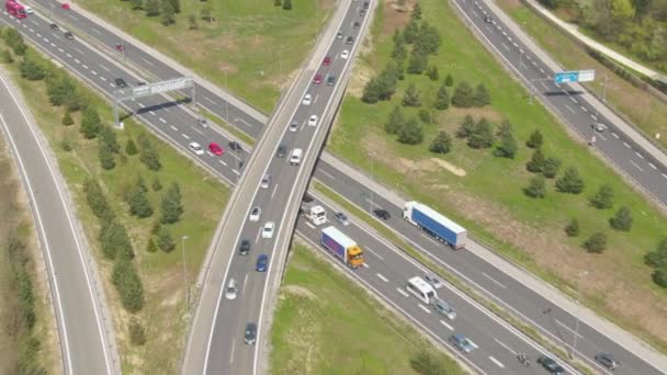 AERIAL Witte vrachtauto rijdt onder snelweg viaduct vol drukke verkeer — Stockvideo