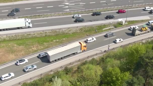 DRONE: Μεγάλο πορτοκαλί 18 wheeler ακολουθεί τη συμφόρηση της κυκλοφορίας κατά μήκος της λωρίδας εισόδου. — Αρχείο Βίντεο