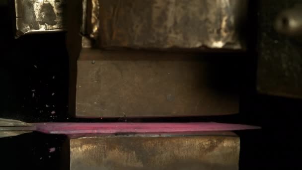 CLOSE UP: Велика машина готує гарячий шматок блискучого металу в лезо ножа . — стокове відео