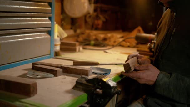 FERMER : Un artisan inspecte un morceau de bois avant de fabriquer une poignée de couteau. — Video