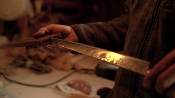 CHIUSURA: Bladesmith inserisce un coltello tradizionale finito nella guaina di legno. — Video Stock