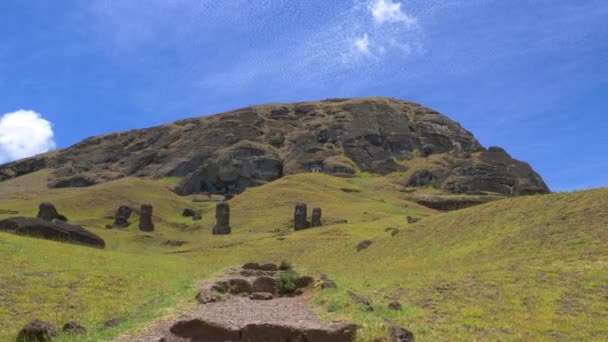 Tajemnicze moai posągi stoją przed pustym szlakiem prowadzącym do wulkanu.. — Wideo stockowe
