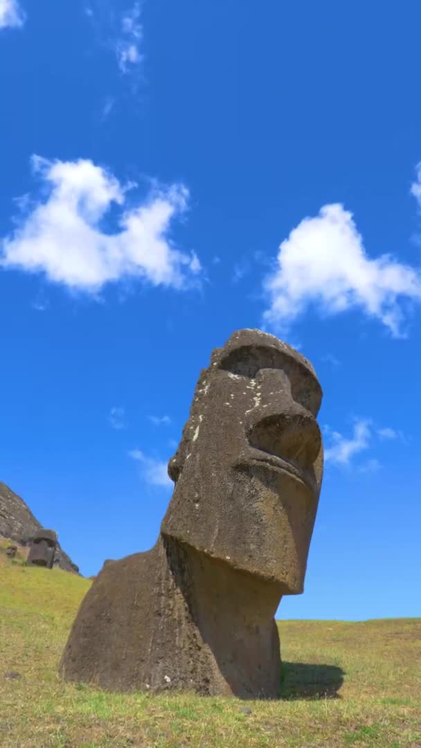 Жорсткі білі хмари дрейфують над великою скульптурою моаї в сонячний день — стокове відео