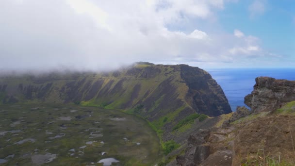 Σύννεφα αιωρούνται πάνω από τον τεράστιο ηφαιστειακό κρατήρα στην άκρη του νησιού. — Αρχείο Βίντεο