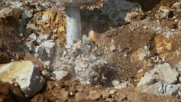 关闭大型工业大锤在泥土深处脉动和压碎岩石 — 图库视频影像