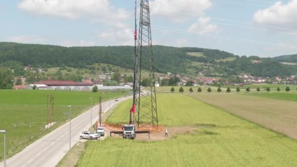 AERIAL: Electricistas en elevador telescópico de brazo trabajando en un pilón eléctrico . — Vídeo de stock