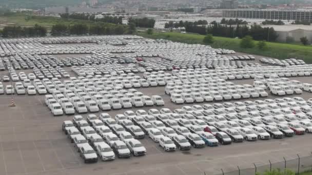 DRONE: Inúmeros carros estão perfeitamente estacionados em linhas em um grande estacionamento de armazenamento. — Vídeo de Stock