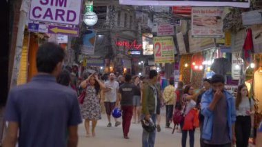 İnsanlar akşamları Katmandu 'da kalabalık bir caddede bir aşağı bir yukarı yürürler..