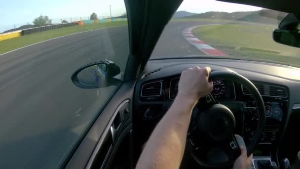 CHIUSURA Irriconoscibile guida in auto da corsa che accelera lungo la pista vuota in una giornata di sole — Video Stock