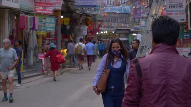 Žena s maskou prochází kolem kamery pohybující se přes Káthmándú.. — Stock video