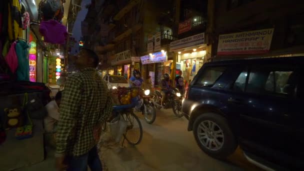 Sluiten: Lokale mensen fietsen en rijden auto 's langs souvenirwinkels en cafés. — Stockvideo