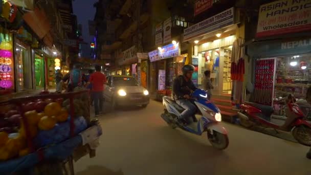CERRAR: El tráfico de la ciudad se mueve a lo largo de las coloridas tiendas de recuerdos en Katmandú. — Vídeo de stock