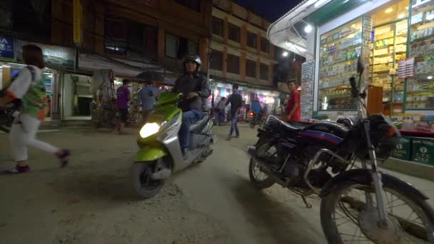 CLOSE UP: Inwoners op fietsen en motorfietsen rijden langs toeristen die winkels bezoeken. — Stockvideo