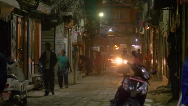 Sluiten omhoog: Inwoners op motorfietsen rijden langs de drukke toeristische straat 's nachts. — Stockvideo