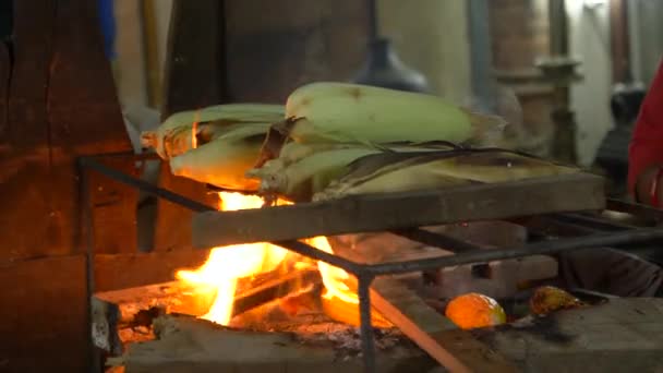 CERRAR: Mujer irreconocible asando maíz sobre el fuego ardiendo en su puesto . — Vídeo de stock