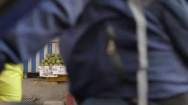 Meyve dükkanındaki çocuk trafikte hareket eden yayaları izliyor..