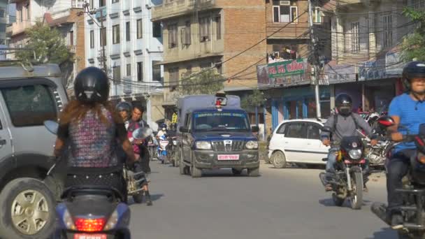 LOW MOTION: Pessoas locais andando de motos e carros de condução em Kathmandu . — Vídeo de Stock