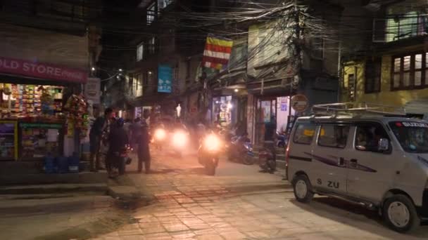 SLOW MOTION: Lokale bevolking van Kathmandu rijden scooters uit een zijstraatje. — Stockvideo