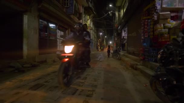 低角度徒歩やスクーターで地元の人々は貧しい状態で街の通りを探索します — ストック動画