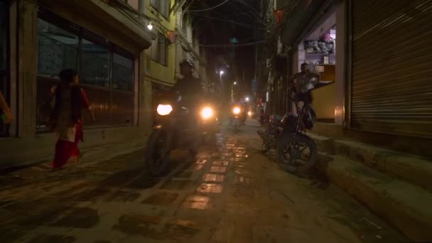 SLOW MOTION: Einheimische auf Motorrädern fahren an einem Souvenirladen in Kathmandu vorbei. — Stockvideo