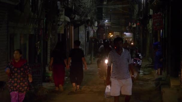 CLOSE UP: Fußgänger und Motorradfahrer teilen sich in Kathmandu dieselbe dunkle Straße — Stockvideo