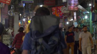 Gezginler ve yerel halk renkli hediyelik eşya dükkanlarının önünden geçiyor..