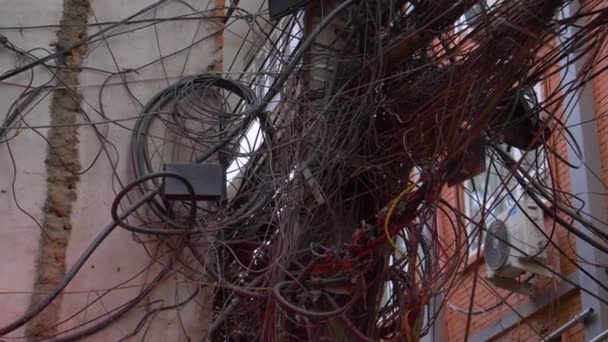 CLOSE UP: Detailed shot of black telephone and electricity cables tangled up. — Stock Video