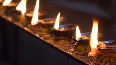 Tapınaktaki küçük yağ mumlarının içinde titreşen alevlerin güzel görüntüsü.