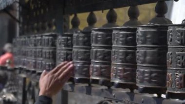 Tibet 'e tapan kişi elini metal dua tekerlerinde gezdiriyor..