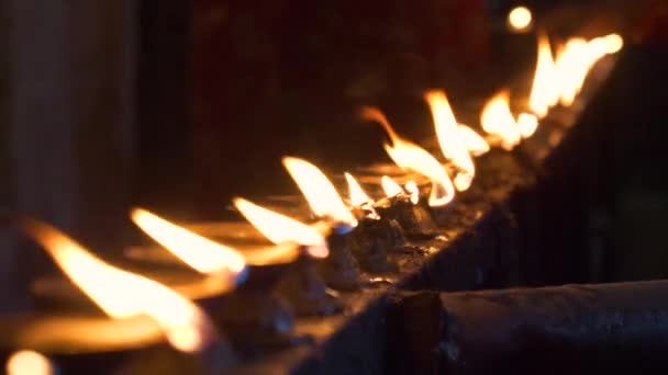 CLOSE UP: People come to a hindu temple and light up oil candles as offerings. — Stock Video