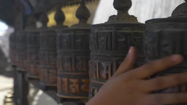 CLOSE UP: Невпізнаваний практикуючий буддизм, що кружляє стародавні молитовні колеса . — стокове відео