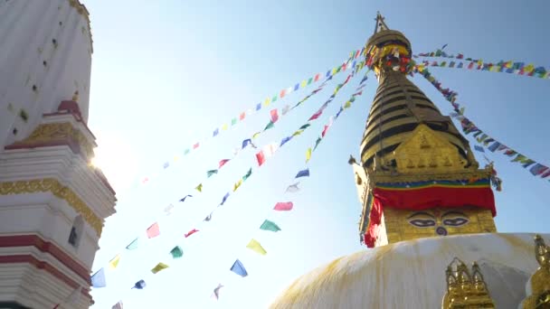 SUN FLARE: hisnande utsikt över rep fulla av flaggor hängande från toppen av stupa — Stockvideo