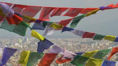 Dalgalanan dua bayraklarının arkasındaki Katmandu şehrinin çarpıcı görüntüsü.