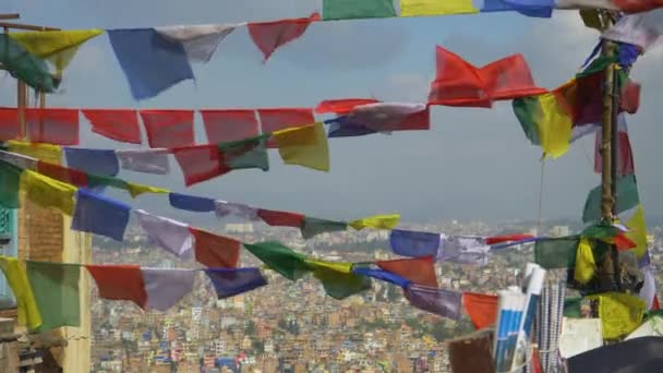CERRAR: Vista panorámica de la ciudad de Katmandú detrás de las banderas de oración ondeantes. — Vídeos de Stock