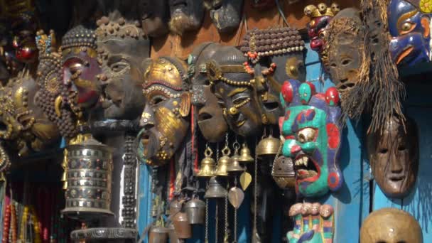 CERRAR: Máscaras budistas tradicionales de madera cuelgan en la pared de una tienda de recuerdos. — Vídeos de Stock