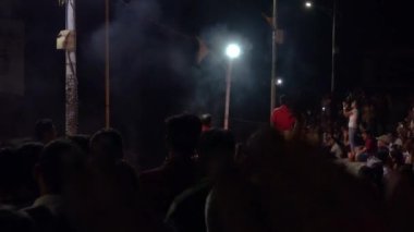 Yerel halk bir tapınakta yapılan hava gömme töreninde gözlemleyip alkışlıyor..