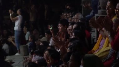 Kalabalık alkışlarken çocuk akıllı telefonuyla Hindu ritüelini filme alıyor..
