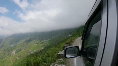 Nepal 'deki ormana bakan engebeli yolun kenarında araba sürüyorum..