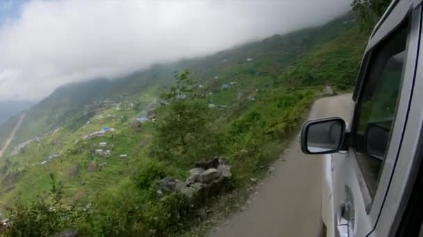 POV: Eng uitzicht op een bos onder je als je langs een onverharde weg in Nepal rijdt. — Stockvideo